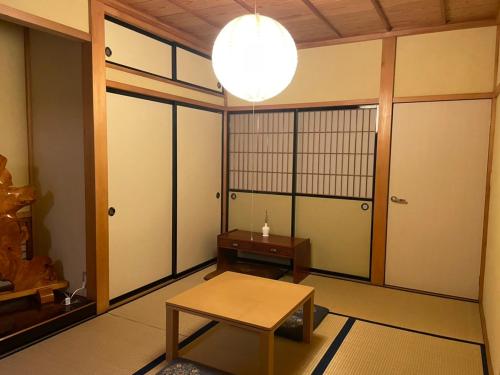 a room with a table and a room with doors at Hidamari in Takayama