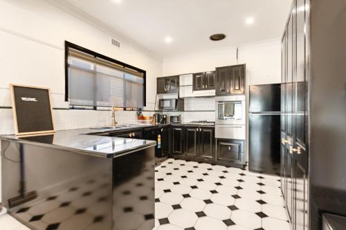 a kitchen with stainless steel appliances and a checkered floor at 3 Bedrooms By The Lake, Top Location in Wendouree