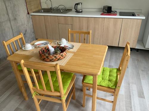 a wooden table with chairs and a bowl of food on it at Lomas Loft in Santiago