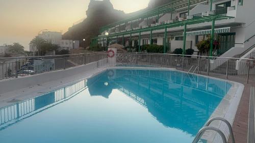 a large blue swimming pool next to a building at Tuneras Sunset Puerto Rico Apartment in Mogán