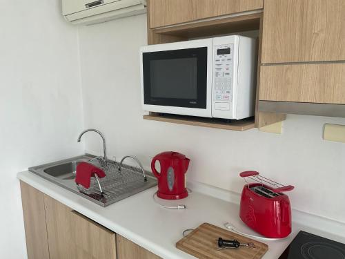 a kitchen counter with a microwave and red appliances at Lomas Loft in Santiago