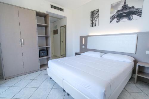 a bedroom with a large white bed in a room at Hotel Carlton in Riccione