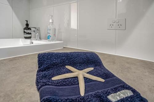 a blue towel with a starfish on the floor of a bathroom at Beachfront self contained upstairs apartment in Semaphore
