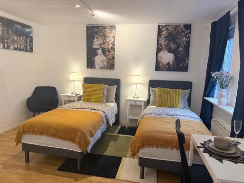 a bedroom with two beds and a table and chairs at Noah Longstay Nordhemsgatan 23 in Gothenburg