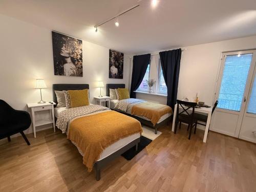 a bedroom with two beds and a desk and window at Noah Longstay Nordhemsgatan 23 in Gothenburg