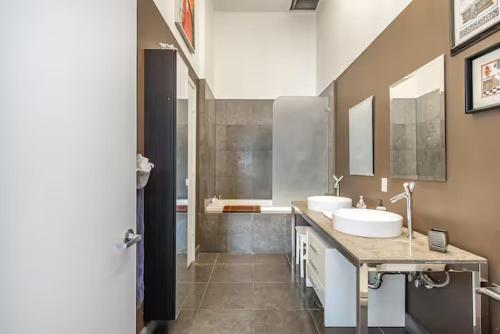 a large bathroom with two sinks and a shower at Beautiful Icon Brickell Double height ceiling in Miami