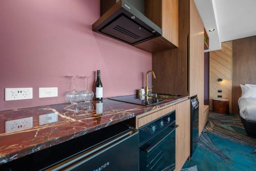 a kitchen with a sink and a bottle of wine at George Hotel Launceston, an Ascend Collection Hotel in Launceston