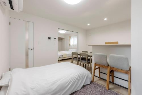 a bedroom with a bed and a table and chairs at Anecis Honjin in Nagoya