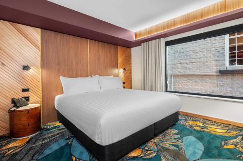 a hotel room with a bed and a window at George Hotel Launceston, an Ascend Collection Hotel in Launceston