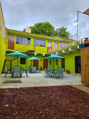 budynek z krzesłami i parasolami przed nim w obiekcie Habitaciones CASA BULE w mieście Oaxaca