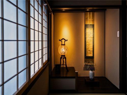 a lamp sitting on a table in a room with windows at Kyoto Inn Gion in Kyoto