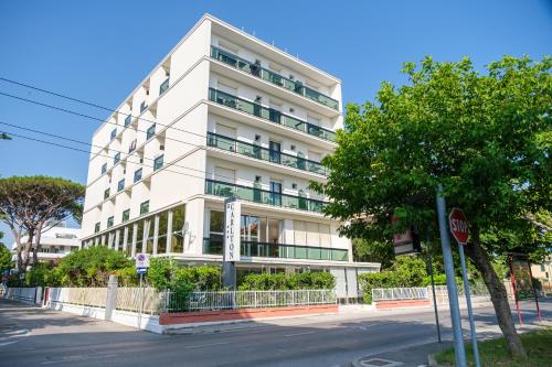 a white building on a street with a stop sign at Hotel Carlton in Riccione