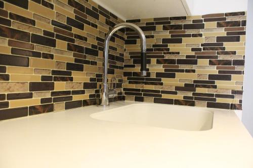a sink in a bathroom with a brick wall at The Nest in Toronto