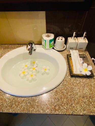 a bathroom sink with flowers on top of it at Nong Khiaw IVY Mountain View in Nongkhiaw