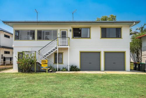 a white house with two garage doors at SunnySide Down 23 McDonalds Place Evans Head in Evans Head