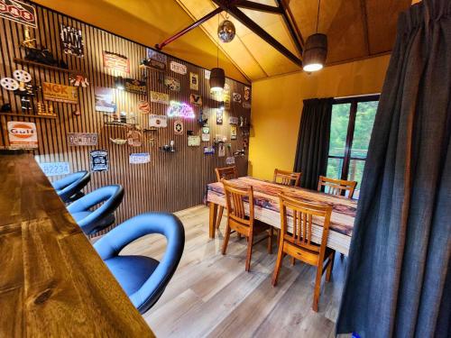 a dining room with a long table and blue chairs at 702 Retro Cooloola Villa, Kingfisher Bay K'gari in Kingfisher Bay