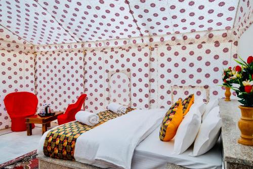 a bedroom with a bed in a tent at HAMIRGARH LUXURIOUS DESERT CAMP & RESoRT in Jaisalmer