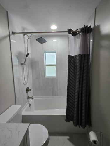 a bathroom with a tub and a shower with a shower curtain at MidCity Country Charm in Cincinnati