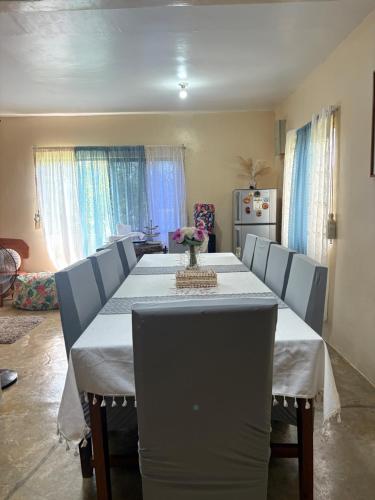 een eettafel met stoelen en een wit tafelkleed bij 5 Bedrooms Beach House in Pilar