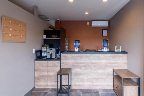 a bar in a restaurant with two stools at HOTEL R9 The Yard Honjowakaizumi in Honjo