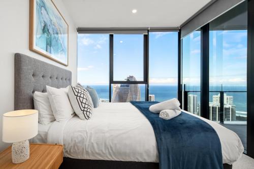 a bedroom with a large bed and large windows at Casino & Luxury Sky High Oceanview 2BR 2BA Parking in Gold Coast