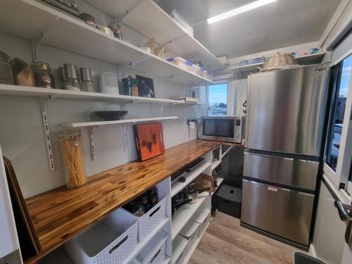 a kitchen with a refrigerator and a wooden floor at Pukeko Cottage in Richmond