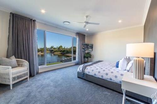 una camera da letto con un letto e una grande finestra di Capri Waterfront Resort-Style 5BR & Pool a Gold Coast