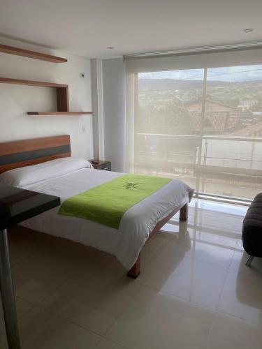 a bedroom with a bed and a large window at Hotel Campestre Villa Juliana in Chía