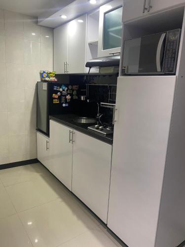 a kitchen with a white refrigerator and a microwave at Hotel Campestre Villa Juliana in Chía