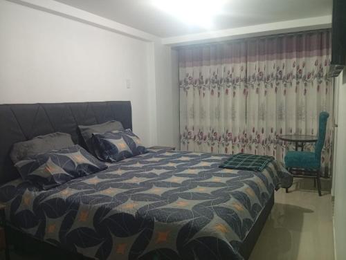 a bedroom with a bed and a table at Hospedaje Residencial Aeropuerto in Zamacola