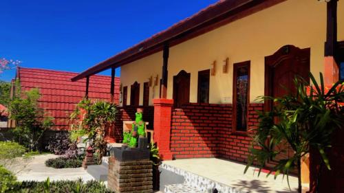 a house with a red and yellow brick at Eco Moringa Garden in Banyuwedang