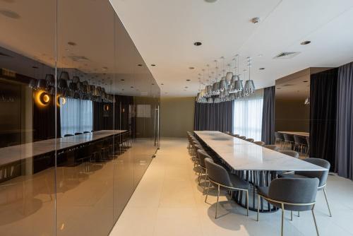 a dining room with a long table and chairs at Novotel Rockwell View Hotel Residences in Manila