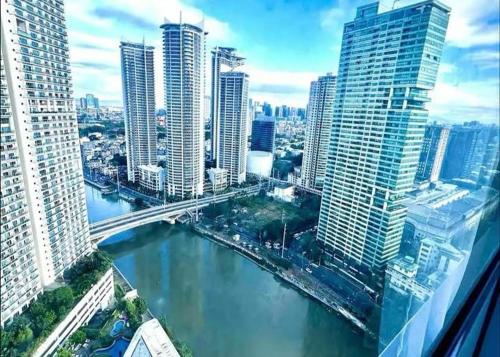 a view of a river in a city with tall buildings at Novotel Rockwell View Hotel Residences in Manila