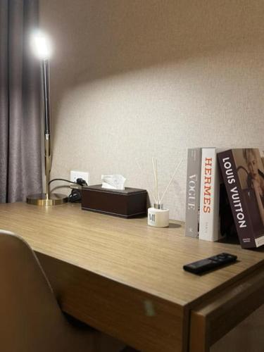 a desk with a book and a remote control on it at Novotel Rockwell View Hotel Residences in Manila