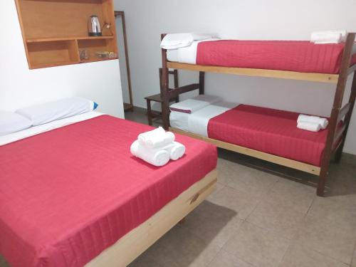 una camera con due letti con lenzuola rosse e bianche di Los Jazmines depto a Cafayate
