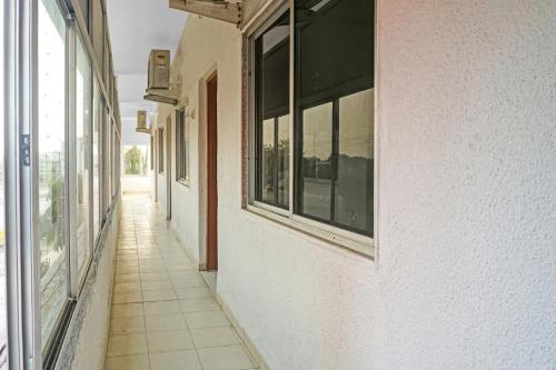 an empty hallway of a building with windows at Hotel O Gold Castle in Shikrapur