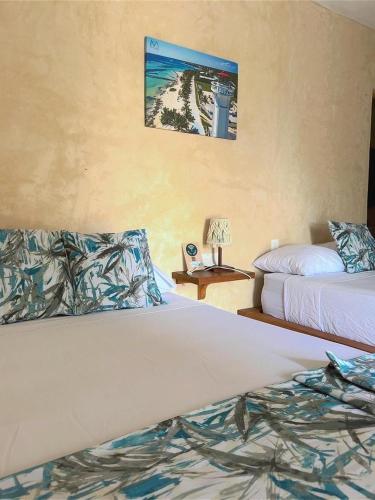 a hotel room with two beds and a table with a lamp at Hotel & Eco Cabañas Azul María Bacalar- Gratis Club de playa in Bacalar