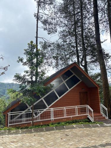 a small house with a large balcony in the woods at Cabinlyfe by MHM in Bandung
