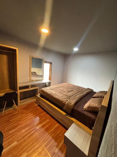 a bedroom with a bed and a window at Cabinlyfe by MHM in Bandung