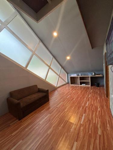 a living room with a couch and a large window at Cabinlyfe by MHM in Bandung