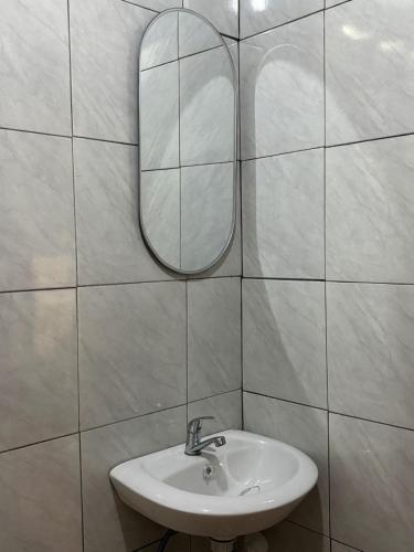 a white bathroom with a sink and a mirror at Cabinlyfe by MHM in Bandung