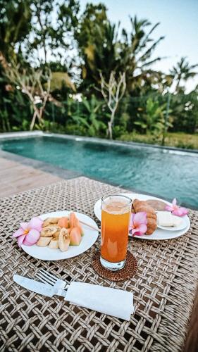 una tavola con piatti di cibo e un bicchiere di succo di Villa Kerta Ubud a Gianyar