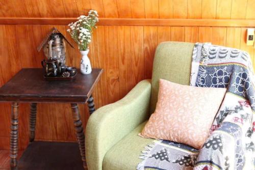 a room with a chair and a table with a vase at The Sound Of Silence Homestay Đà Lạt in Da Lat