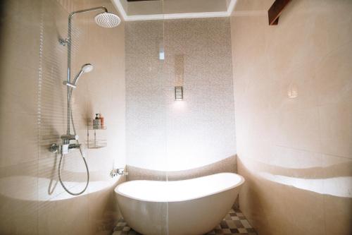 a bathroom with a shower and a tub and a toilet at Villa Kerta Ubud in Gianyar