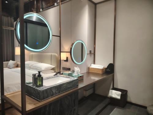 a bathroom with a sink and two mirrors at Floral Hotel Taipingli in Quanjiao