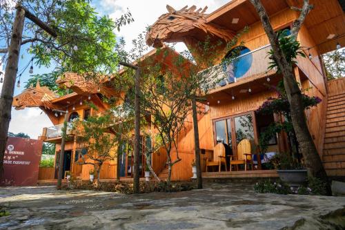 a wooden house with a patio in front of it at Bac Ha Horse Farmstay in Bắc Hà