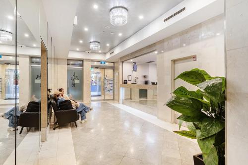a group of people sitting in chairs in a lobby at MetaWise 1Bed Next to ICC Darling Harbour 154 in Sydney