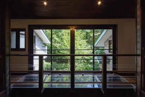 a view from the balcony of a house with a large window at 悠流里 Inn YURURI 温泉露天風呂付き in Nasu