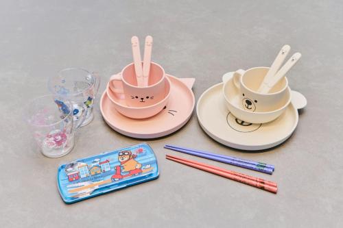a table with two cups and plates with chopsticks at 犬山口駅10分 80インチ映画館有 無料駐車場 ベッド6台 ソファベッド1台 83平米 最大10名宿泊可 in Inuyama