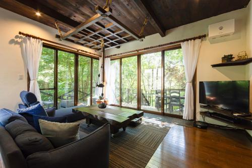 a living room with a couch and a table at 悠流里 Inn YURURI 温泉露天風呂付き in Nasu